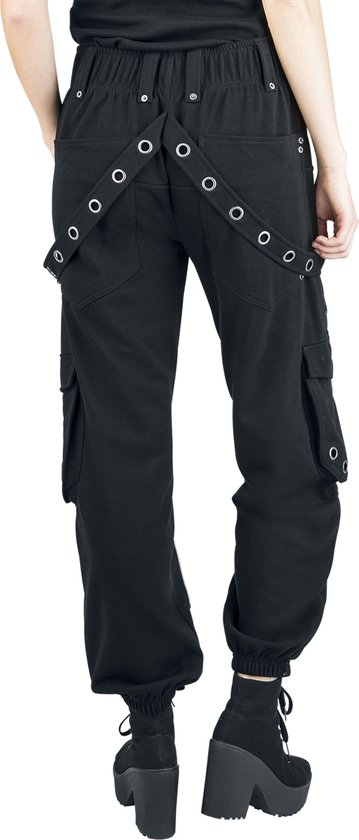 Model van achteren in zwarte cargo broek met ritsen, oogjes en banden over de rug, met platform laarzen.
