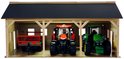 Houten landbouwloods met zwarte dak. Rode tractor, groene tractor en rode aanhanger.