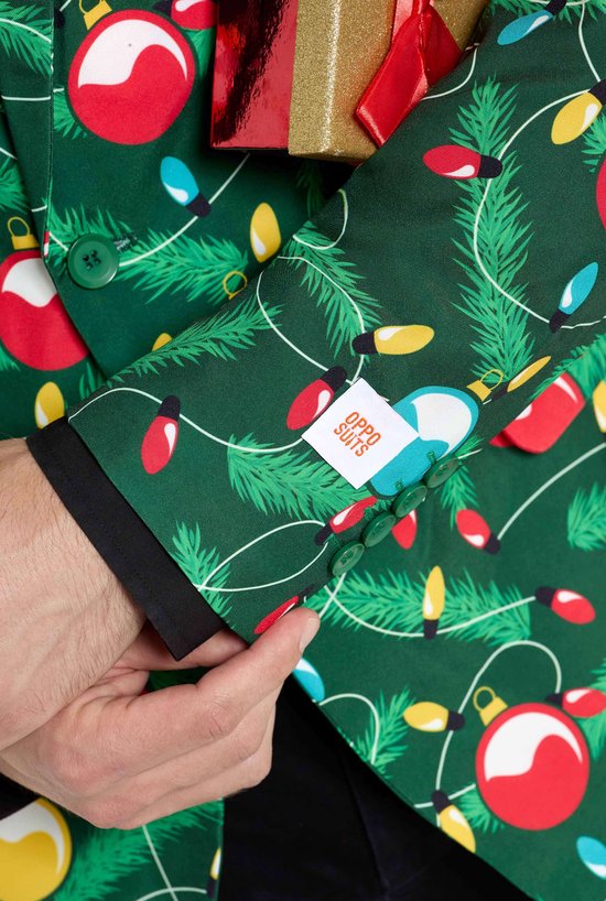Detail van groen colbert met kerstopdruk. De binnenkant van de mouw is zichtbaar, met een label van OppoSuits.