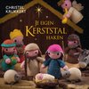Een gehaakte kerststal met Maria, Jozef, het kindje Jezus, schapen, een ezel en een engel. De titel 'Je eigen Kerststal haken' staat centraal.