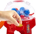 Hand plaatst muntje in rode snoepautomaat met blauwe Hot Wheels ballen