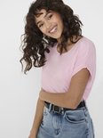 Zachtroze t-shirt met omgerolde korte mouwen, gedragen door een model.
