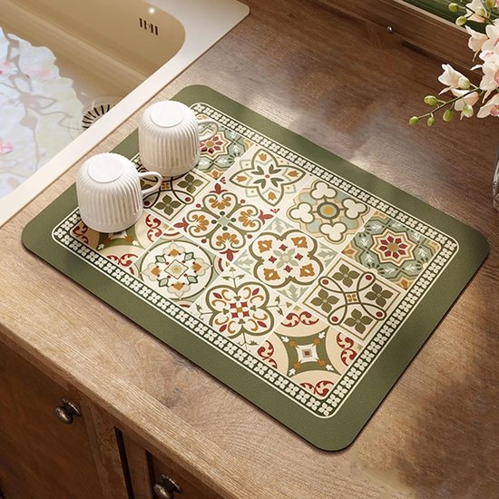 Olijfgroene onderlegger met geometrisch tegelpatroon, witte rand, bij de gootsteen met twee witte kopjes.