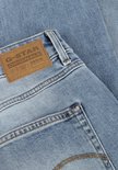 Close-up van het bruine G-Star Raw Denim label op een lichtblauwe jeans.