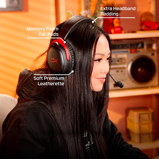 Vrouw draagt een zwarte gaming headset met rode accenten. Indicaties voor 'Memory Foam Ear Pads'.