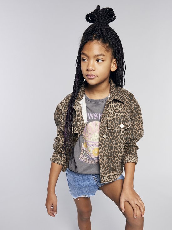 Jeune fille aux cheveux tressés porte une veste imprimé léopard, un t-shirt gris et un short en jean.