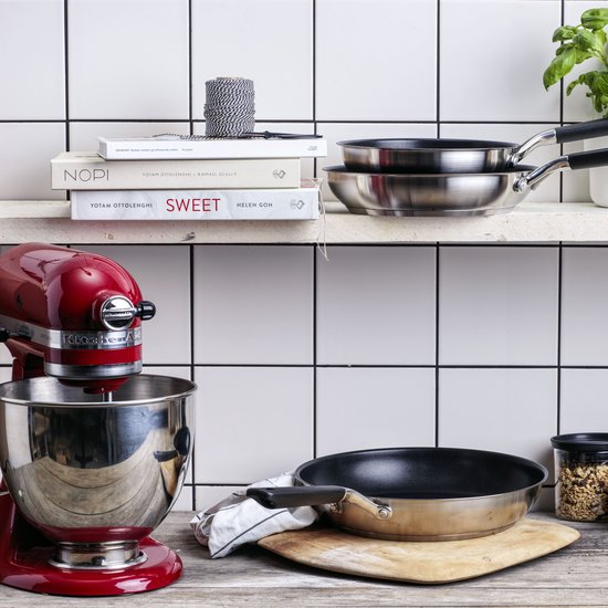 Keukenopstelling met rode mixer, twee pannen en kookboeken.
