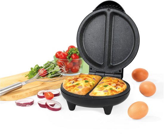 Twee omeletten met groenten en kaas in een zwarte omeletmaker, met ingrediënten ernaast.