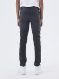 Jongen in grijze slim fit spijkerbroek, staand, gezien vanaf de achterkant.