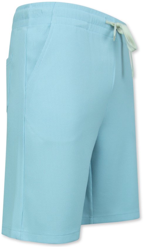 Zijaanzicht turquoise short met wafelpatroon, trekkoord en zak.