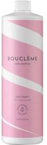 Witte fles met roze en witte diagonale strepen. Tekst: BOUCLÈME, curls redefined, curl cream, plant powered curl care, 1L.