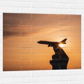 Muursticker - Speelgoed Vliegtuig in Mensenhand bij Zonsondergang - 100x75 cm Foto op Muursticker