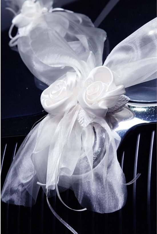 Close-up van een witte organza strik met twee rozen voor op een auto.
