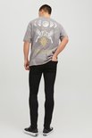 Man met grijze t-shirt met 'Eternal Paradise' print, zwarte skinny jeans en zwart-witte sneakers, van achteren gezien.