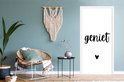 Porte blanche avec le texte noir 'geniet' et un petit cœur, dans un salon.