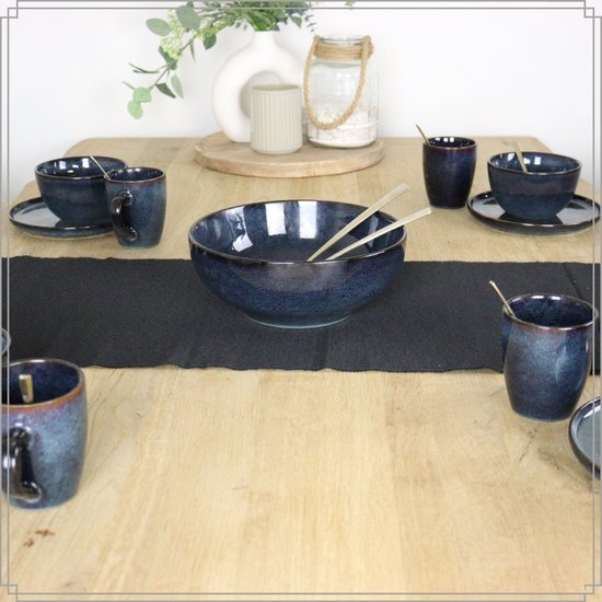 Gedekte tafel met zes blauwe mokken en kommen, met gouden bestek.
