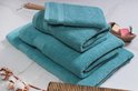 Une pile de serviettes bleu clair avec un motif détaillé sur les bords, avec une plus petite serviette sur le dessus.