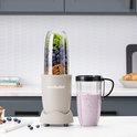 Linnen beige Nutribullet met beker vol bosbessen en pecannoten en een smoothie in een beker met handvat.