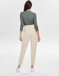 Groene coltrui met lange mouwen, gedragen door een vrouw, achterkant zichtbaar met beige broek.