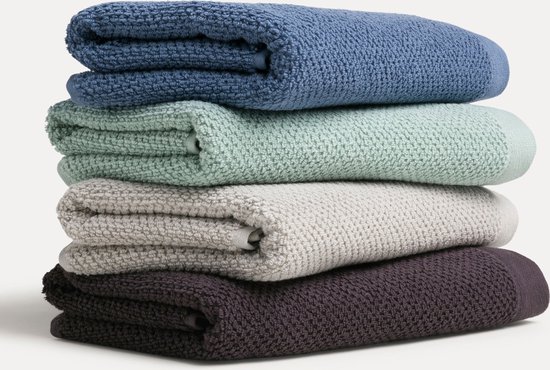 Stapel van vier zachte handdoeken in blauw, mintgroen, grijs en donkerpaars.