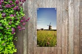 Tuinposter Een molen met bloemen - 40x80 cm - Wanddecoratie Buiten - Tuinposter - Tuindoek - Schuttingposter - Tuinschilderij