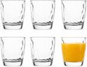 Six verres au motif ondulé unique. Un verre rempli de jus d'orange.