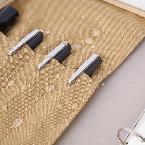Close-up van coyote nylon met waterdruppels en drie pennenvakken met zilveren clips.