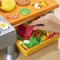 Kind vult Play-Doh groentenbak met een plak tomaat.