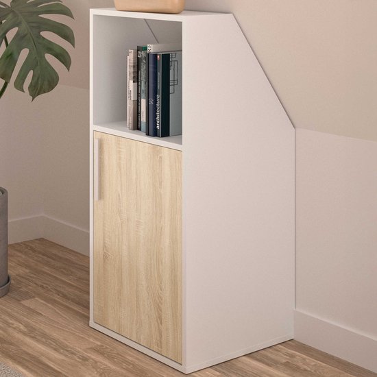 Witte kast met een schuine bovenkant, een houten deur aan de onderkant en een open nis met boeken erboven.
