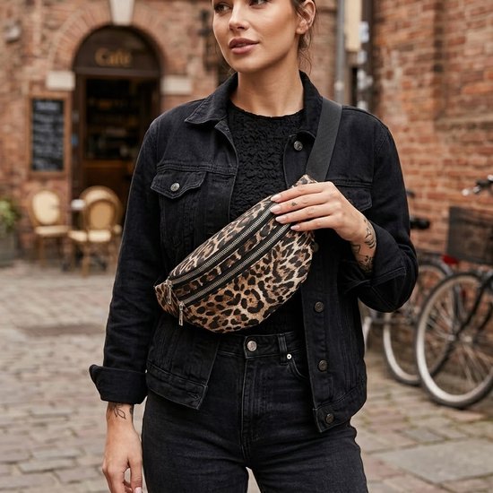 Model met heuptas met luipaardprint en zwarte spijkerjas.