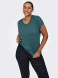 Model lacht en toont een petrolkleurig sportshirt met korte mouwen en een zwarte legging met grafische print.