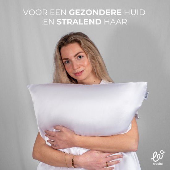 Jonge vrouw met lang blond haar omhelst een glanzende witte kussensloop. Tekst: Voor een gezonde huid en stralend haar.