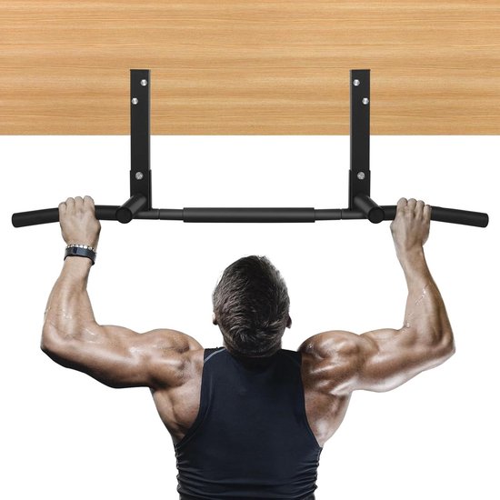 Een gespierde man trekt zich op aan een zwart pull-up rek, gemonteerd aan een houten plafond.
