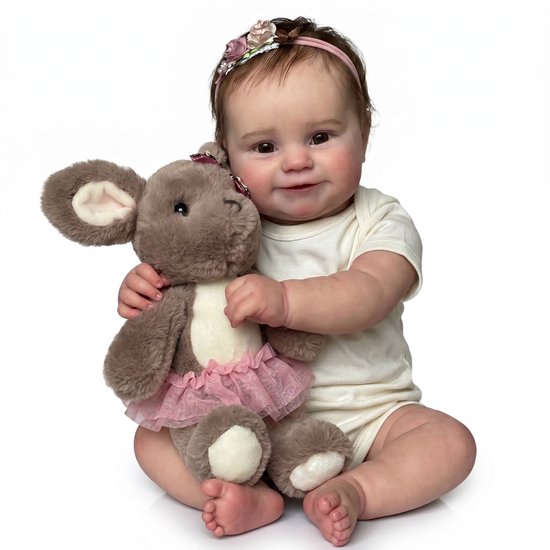 Baby in wit rompertje met roze ballerina rokje knuffel, zittend op witte achtergrond.