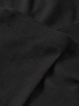 Detail van de naad van een zwarte legging.