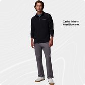 Man in een zwarte Columbia fleecetrui met halve rits en grijze stiksels, met tekst 'Zacht, licht en heerlijk warm.'.