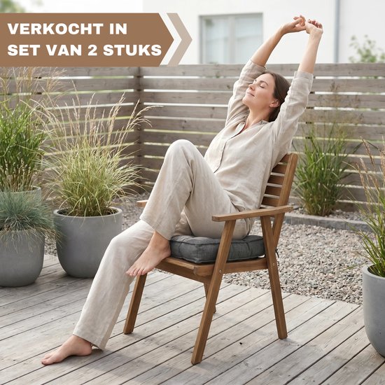 Vrouw strekt zich uit op een houten stoel met een donkergrijs vierkant kussen. Verkocht in set van 2 stuks.