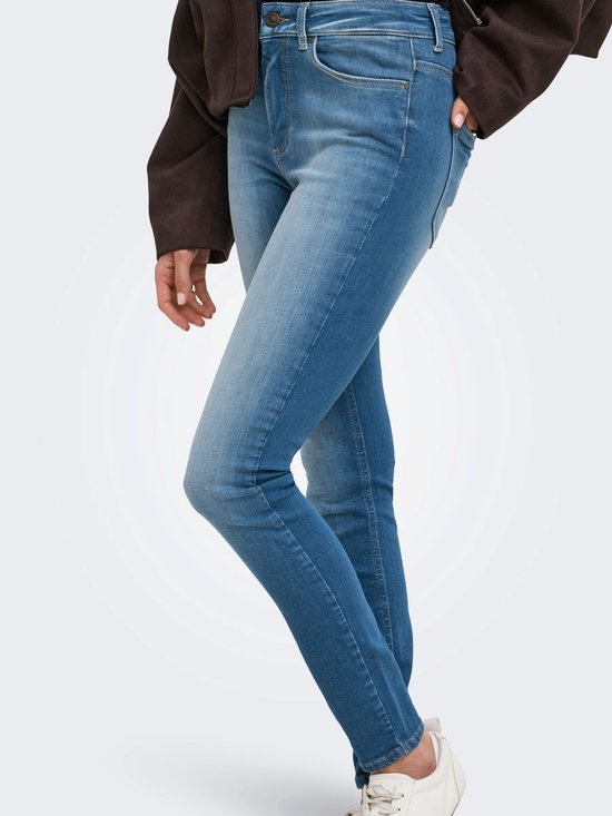 Model draagt een lichtblauwe skinny jeans met hoge taille.