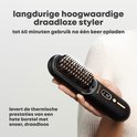 Een zwarte draadloze stijlbortsel met gouden tanden, vastgehouden in een hand.