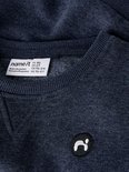 Label van een donkerblauwe sweater met de tekst 'name it' en maatinformatie.