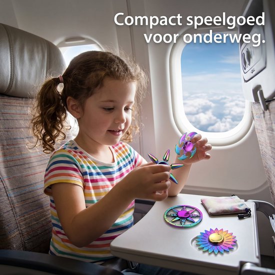 Een meisje met een gestreepte trui speelt met kleurrijke fidget spinners aan boord van een vliegtuig. Compact speelgoed voor onderweg.