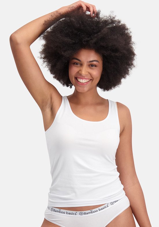 Glimlachende vrouw met afro, draagt een witte singlet. Van de zijkant.