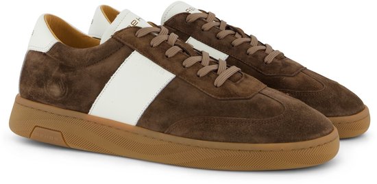 Bruine suède sneakers met een witte streep op de zijkant, witte veters en een bruine rubberen zool.