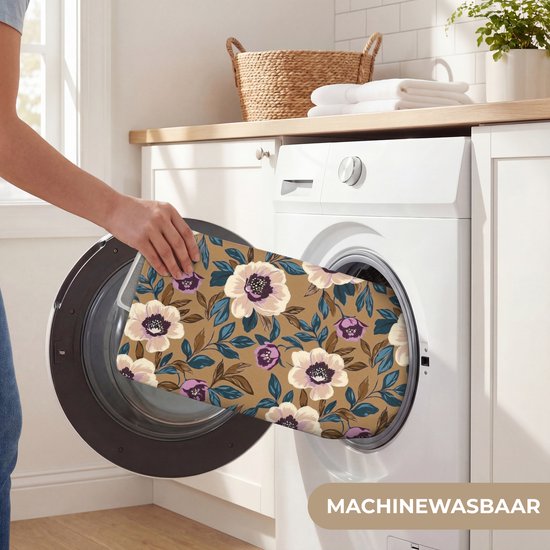 Hand doet een wasbare badmat met bloemenpatroon in de wasmachine.