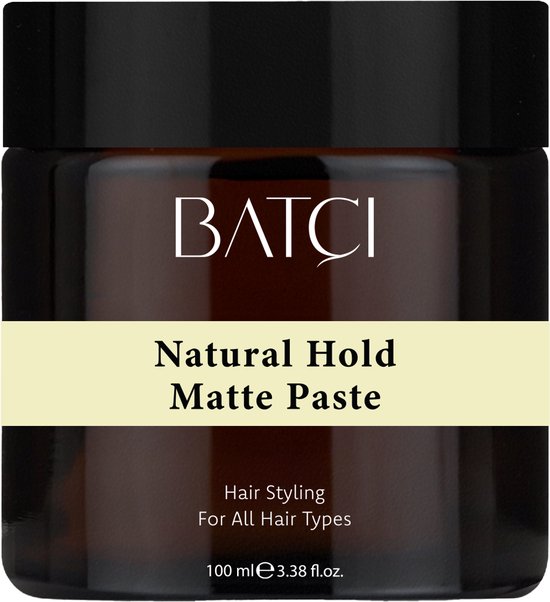 Pot brun avec "Natural Hold Matte Paste" et "Hair Styling For All Hair Types" sur une bande jaune pâle.