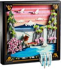 LEGO-landschap met berg, waterval, kersenbloesems en kraanvogels, bij zonsondergang, in zwart kader.