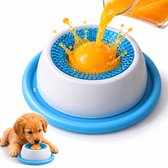 Een gouden puppy likt aan een geel balletje in een blauwe en witte voerbak waar sinaasappelsap overheen wordt gegoten.
