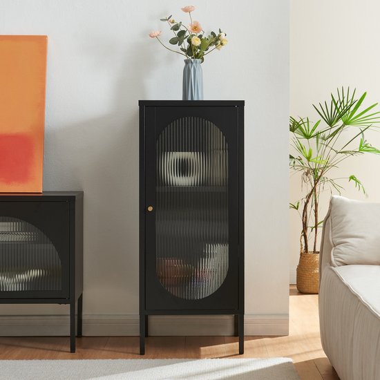 Zwarte kast met gesloten, geribbelde glazen deur in een gestylede woonkamer.