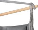 Detail van de ophanging van een grijze hangstoel: houten spreider en touwen.