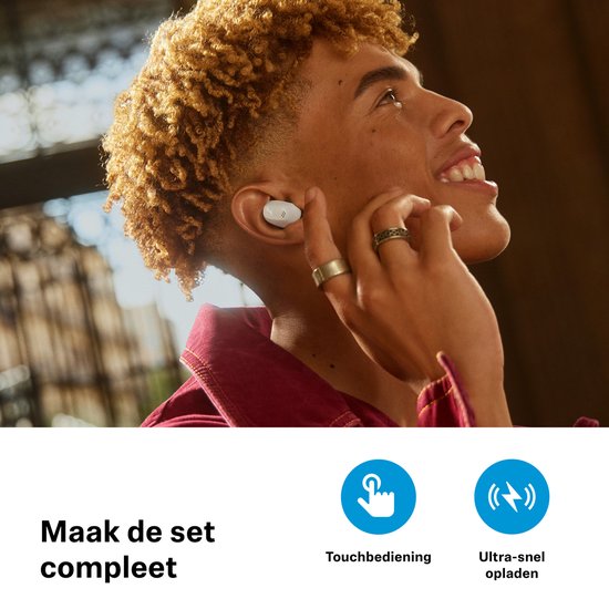 Man met kroeshaar en ringen draagt witte oordopjes. Tekst: Maak de set compleet.